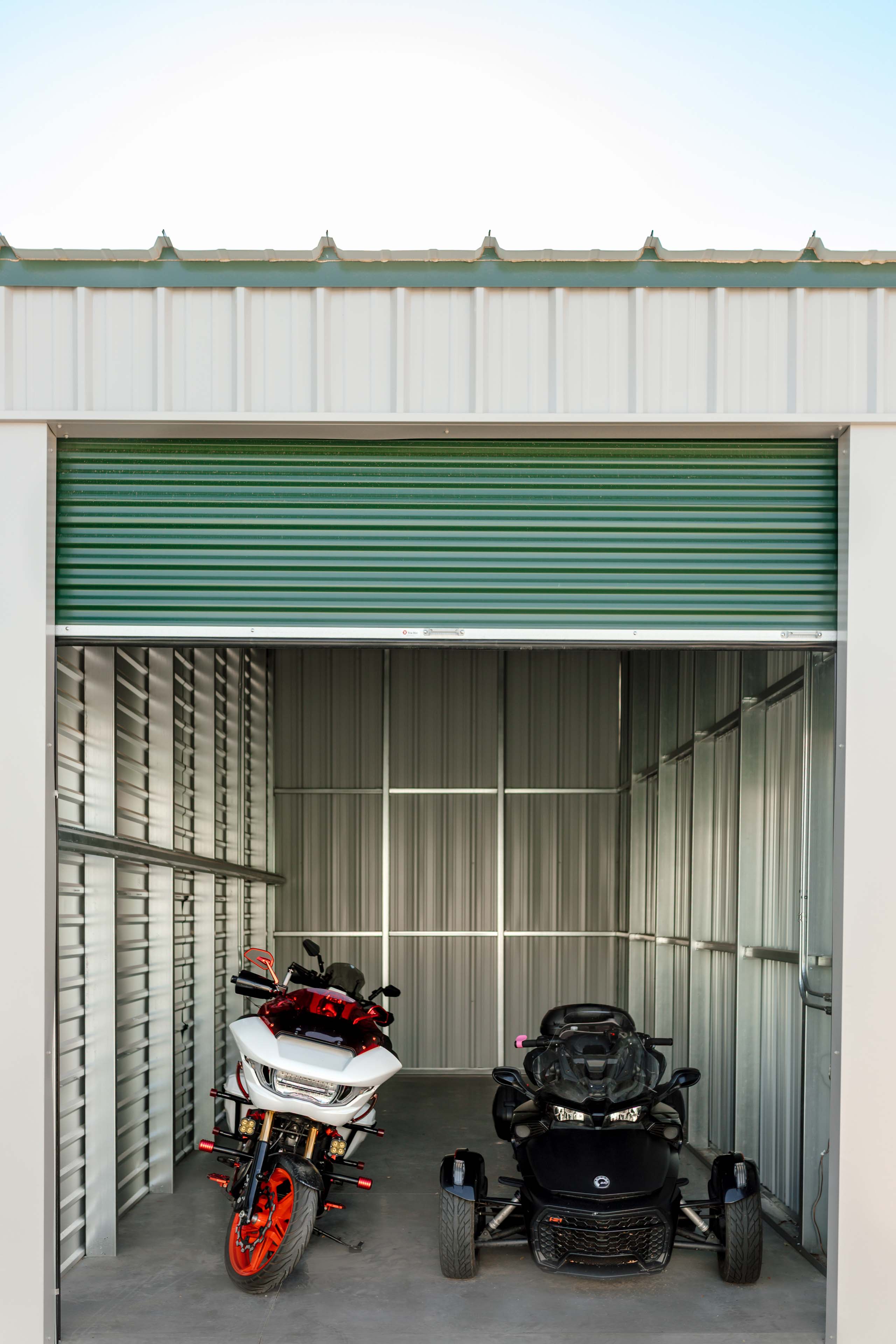 a dirt bike and quad inside of a storage unit